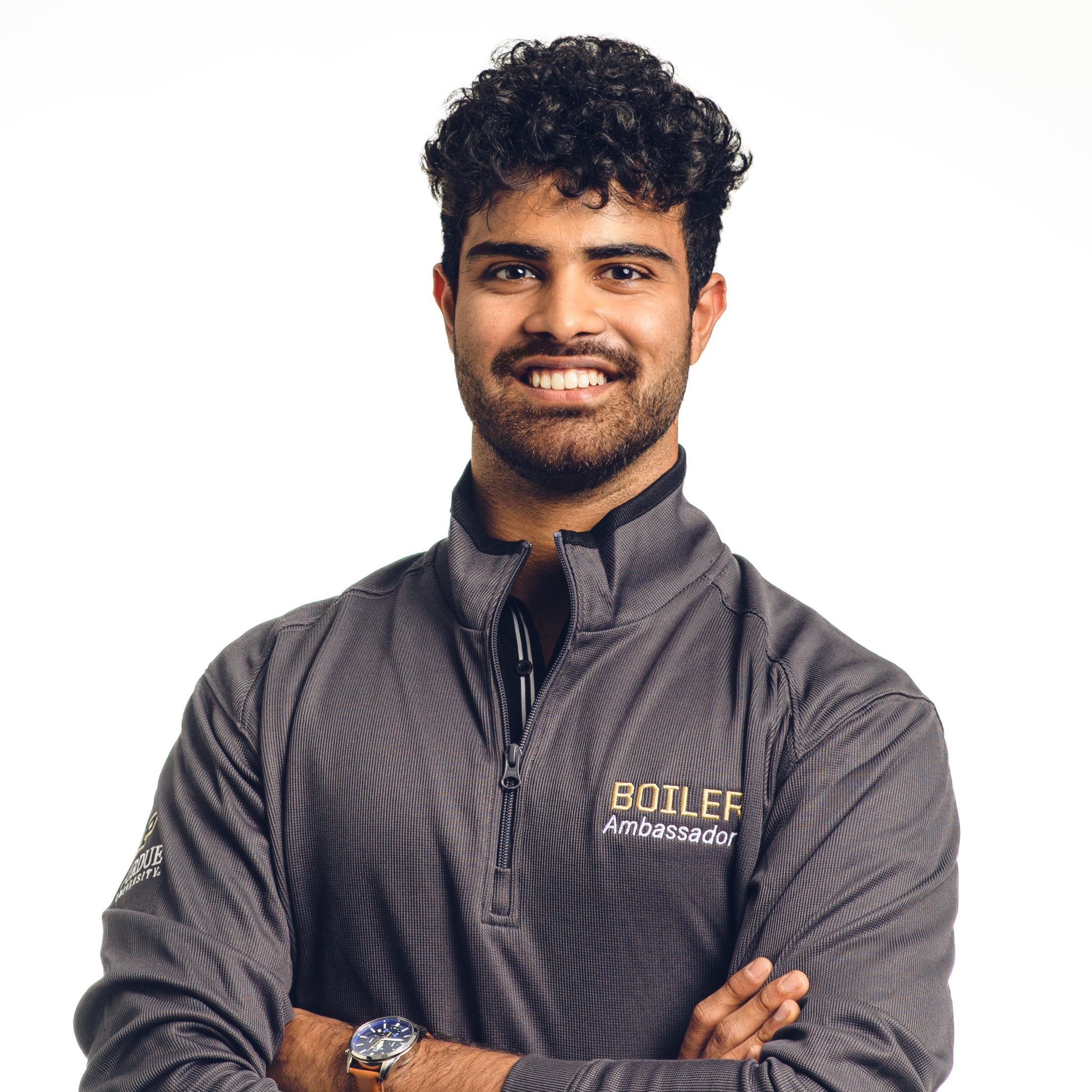 Atharva stands with arms crossed wearing a gray Purdue polo shirt.